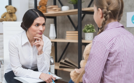Counsellor talking to a child about her mental health