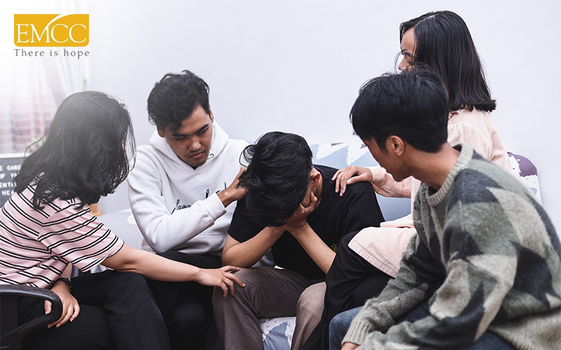group of people consoling a person